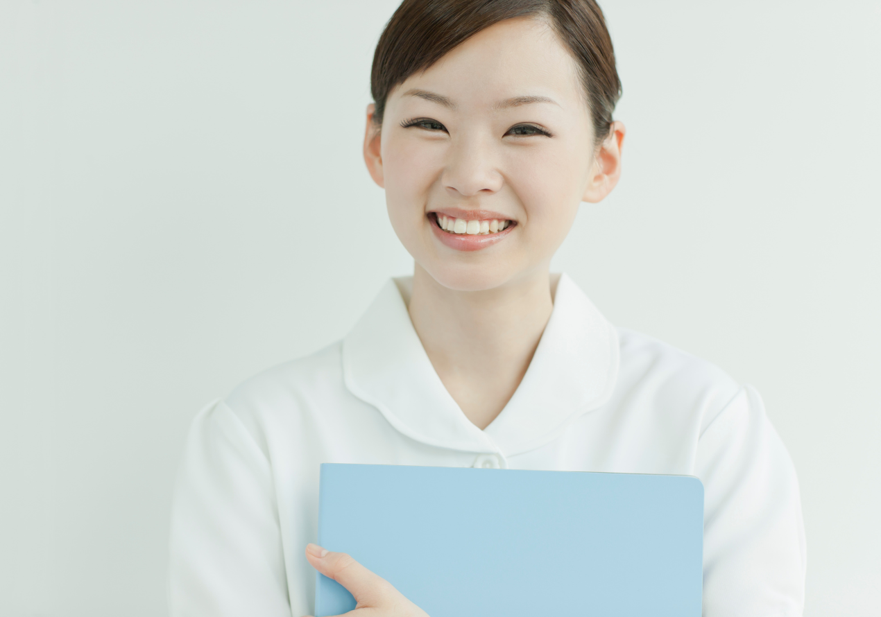 受付でパソコン作業をするアジア系女性スタッフ